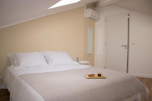 a bedroom with a white bed with a tray on it at Apartamento São Miguel - Santa Catarina Place in Ponta Delgada