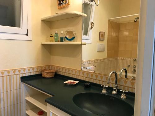 uma casa de banho com um lavatório verde e um espelho em Solimano 50 em Santa Margherita Ligure