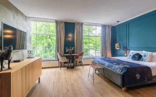 una camera da letto con pareti blu, un letto e un tavolo di Heuvelsuites a Oosterhout