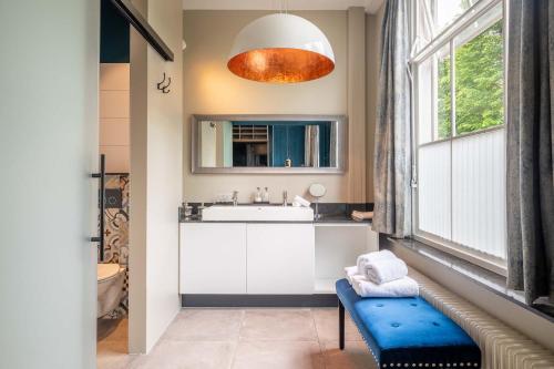 a bathroom with a sink and a toilet and a mirror at Heuvelsuites in Oosterhout