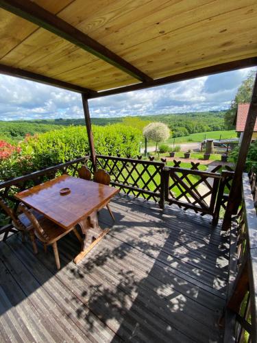 a wooden deck with a table and chairs on it at Cosy mobile house in the heart of Goricko in Moravske Toplice