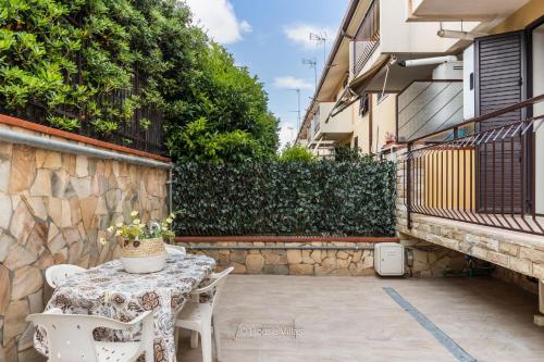 a patio with a table and chairs and a wall at House&Villas - Casa Amica in Avola