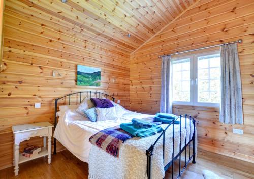 a bedroom with a bed in a log cabin at Silver Birch Lodge in Middleton