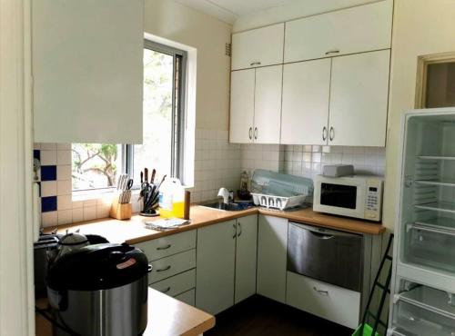a kitchen with white cabinets and a microwave at Close to the famous Bondi Beach in Australia in Sydney