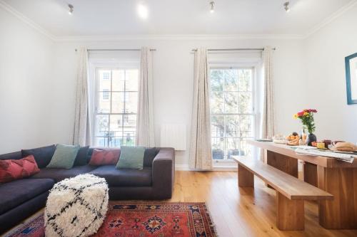 a living room with a couch and a table at King's Cross 3BR - CityApartmentStay in London