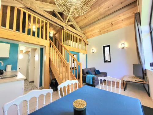 a dining room and living room with a blue table and chairs at Domaine des Cèdres - Hôtel, gîtes et insolites in Villebois