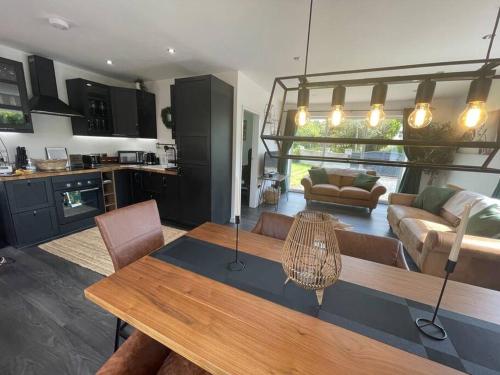 a kitchen and a living room with a wooden table at The Stables,Ashley in Ashley