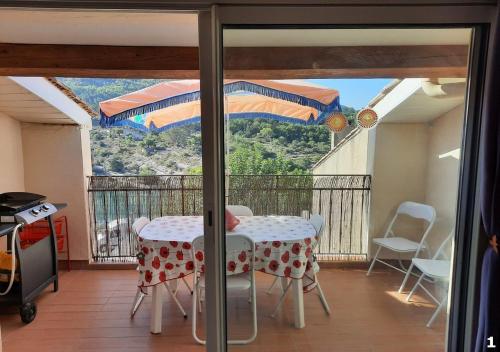 Cette chambre dispose d'une table et d'un balcon avec vue. dans l'établissement Appartements Hameau du Port, à Esparron-de-Verdon