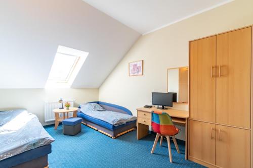 1 dormitorio con 1 cama y escritorio con TV en Pod Platanem, en Rowy