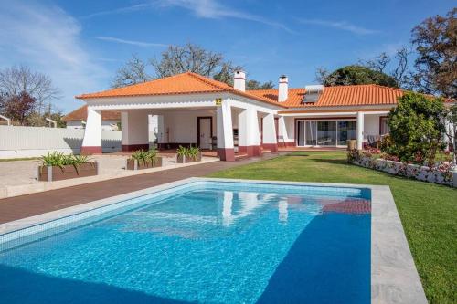 a house with a swimming pool in the yard at Casa de campo e praia in Alfarim