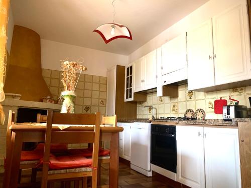a kitchen with white cabinets and a table and chairs at Flowery House in Miglianico