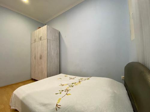 1 dormitorio con 1 cama y armario de madera en Apartment On Luka Asatiani 2 en Batumi