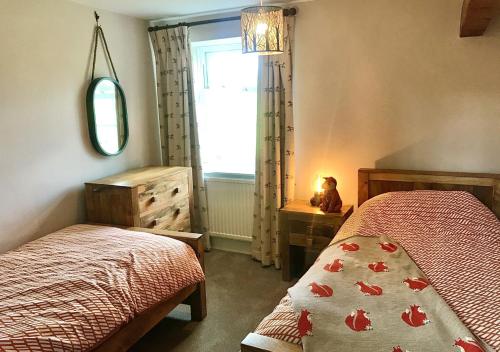 a bedroom with two beds and a window at Seata Barn in Askrigg