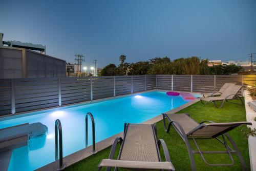 - une piscine avec des chaises sur le toit la nuit dans l'établissement Creta Sun luxury apartments, à Réthymnon