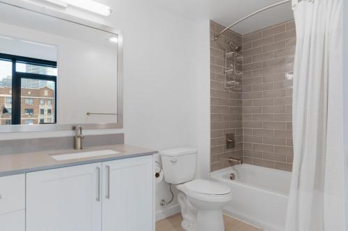 a bathroom with a toilet and a sink and a tub at First Hill 1BR w Gym Patio Coworking SEA-435 in Seattle