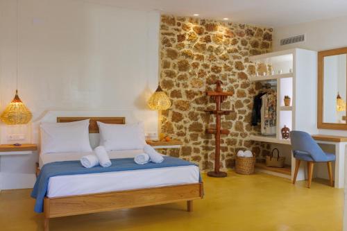 a bedroom with a bed and a stone wall at Dolphin Studios in Malia