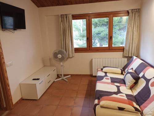 a living room with a couch and a window at El Sindicat de Tarrés Camins de Pedra in Tarrés