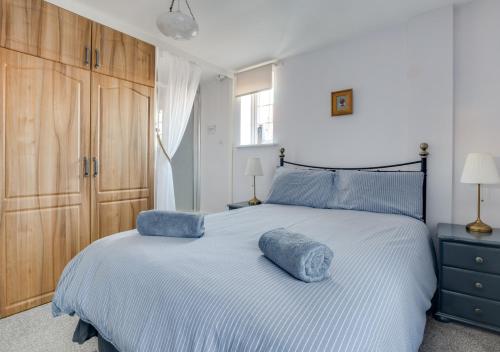 a bedroom with a large bed with blue pillows on it at Seashell Cottage in Whitby