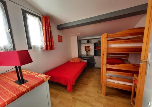 a bedroom with two bunk beds and a red bed at Appartements Hameau du Port in Esparron-de-Verdon