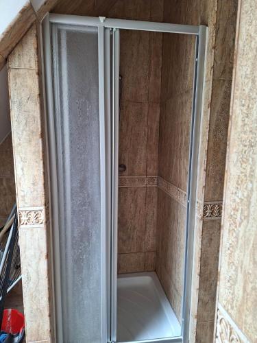 a shower with a glass door in a bathroom at Apartamenty Dom nad Jeziorem in Głęboczek