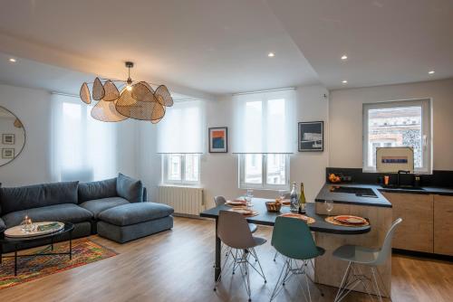 un salon avec un canapé, une table et des chaises dans l'établissement Le Bénédictin - Maison à 200m de la plage, à Fécamp