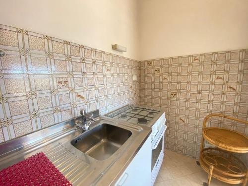 eine Küche mit einer Spüle und einem Herd in der Unterkunft Imperiale Apartment in Tirrenia