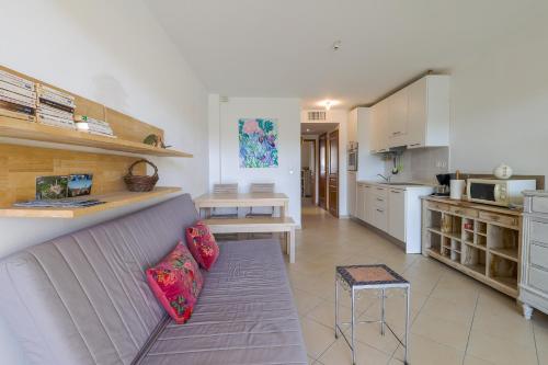 un salon avec un canapé et une cuisine dans l'établissement Résidence Eucalyptus - Appt avec terrasse, à LʼÎle-Rousse