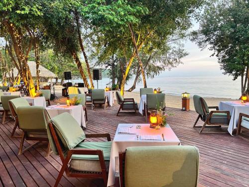 a restaurant on the beach with tables and chairs at Koh Russey Resort in Koh Russey