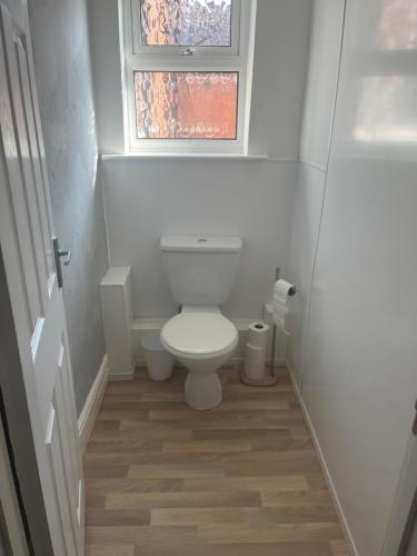 a small bathroom with a toilet and a window at The Laurels Hotel in Skegness
