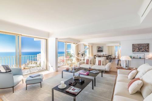 una sala de estar con muebles blancos y vistas al océano. en Easy Clés - Dream view luxury flat AC en Biarritz