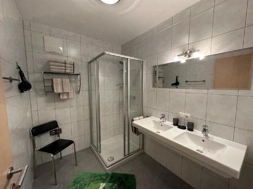 een badkamer met een douche, een wastafel en een glazen douche bij Eichenhof in Reith im Alpbachtal