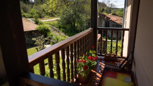 a balcony with a bench with flowers on it at Fuente De Las Anjanas in Estrada