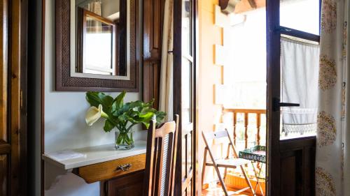 a room with a table and a mirror and a balcony at Fuente De Las Anjanas in Estrada