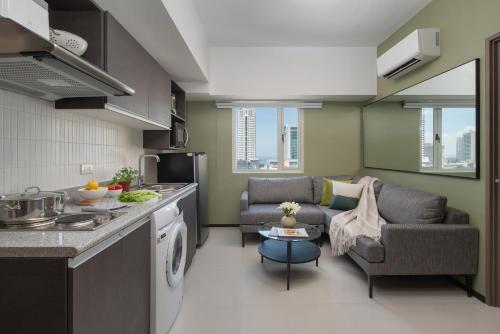 a kitchen and living room with a couch and a table at The Suites at Torre Lorenzo Malate - Managed by The Ascott Limited in Manila