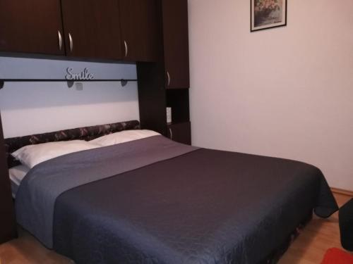 a bedroom with a large bed with a black blanket at Apartment Hortenzija in Baška Voda