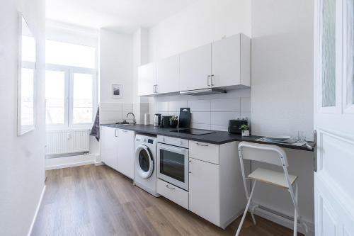 a white kitchen with a sink and a dishwasher at Cozy Apartment in Wiesbaden in Wiesbaden