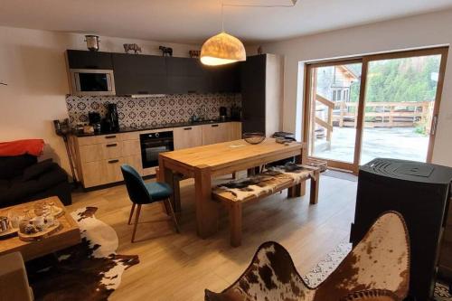 a living room with a table and a kitchen at Chalet 1829 in Sainte-Foy-Tarentaise