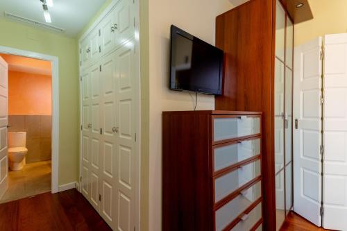 a closet with a flat screen tv and a closet with white doors at Exclusiva Casa en Centro in Seville