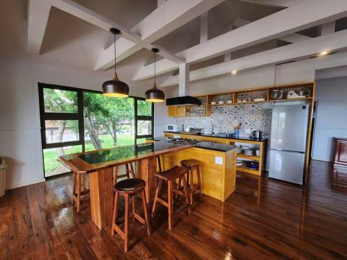 una grande cucina con grande isola in legno con sgabelli da bar di Luxury Seaview Getaway a Lopes