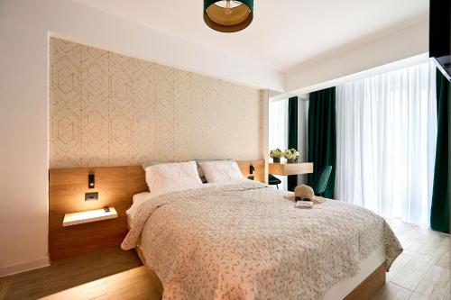 a bedroom with a large bed and a window at Vlezal Apartment Spa&Pool Beach Resort in Mamaia