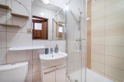 a bathroom with a toilet and a sink and a shower at Pokoje Syberia Morska 20 in Kuźnica