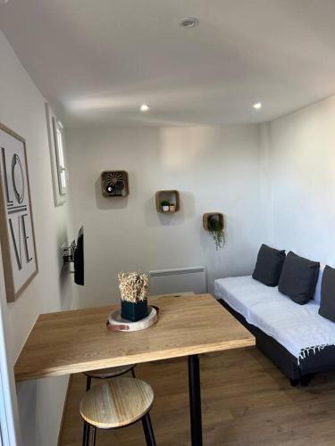 un salon avec une table et un canapé dans l'établissement Appartement Crème, à Manosque