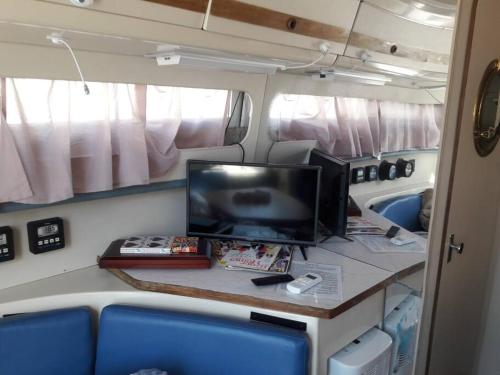 a desk in an rv with a tv and a computer at Waterfront 32' Bayliner Yacht in Providence