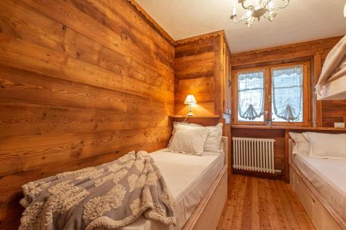 L'Atelier du Temps - Le Petit Refuge Appartement في كوجن: سريرين في غرفة بجدران خشبية