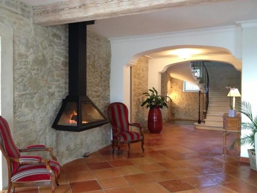 a living room with chairs and a fireplace at Chambres d'Hotes Domaine de la Capelle in Saint-Martin-Lalande