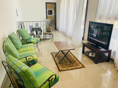 a living room with couches and a television and a table at Lovely penthouse 4- bedroom directly on the lagoon in El Alamein