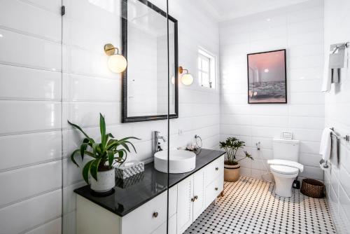 a white bathroom with a sink and a toilet at The Beach House in Canggu