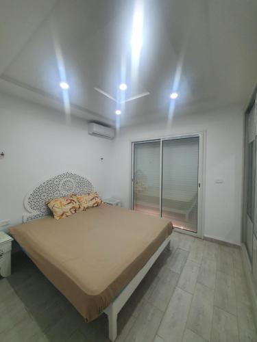 una camera da letto con un letto e luci sul soffitto di Villa de luxe avec piscine sans vis à vis Midoun ad Aghīr