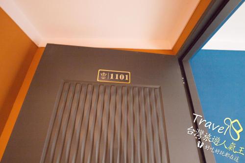 a room with a door with a sign on it at 波西塔諾villa民宿 全新旅店市中心 歐式別墅 親子住宿 in Xiaoliuqiu
