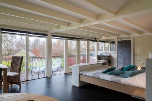 1 dormitorio con 1 cama grande y ventanas grandes en Guesthouse de Heide, en Oeffelt